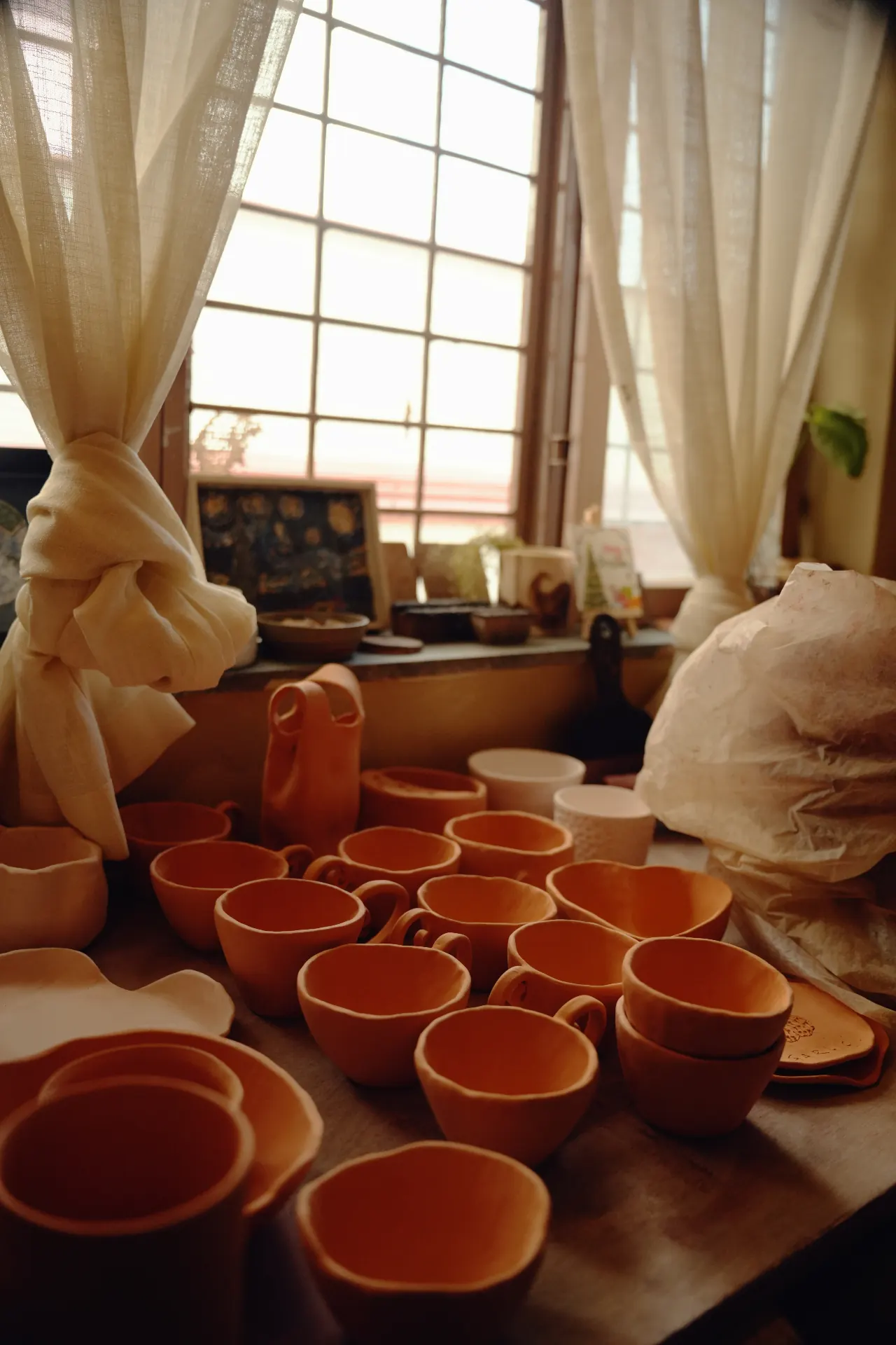 Handmade ceramic mugs and bowls in earthy glazes